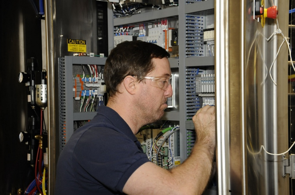 A BW Packaging team member works on an electrical cabinet A BW Packaging team member works on an electrical cabinet